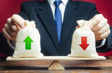 İş adamı teraziyi elinde tutuyor. Özet ve bilanço. Gelir ve maliyet. Ticaret dengesi bütçesi. Finansal yönetim, kâr. Risk planlama. Avantajlar, dezavantajlar