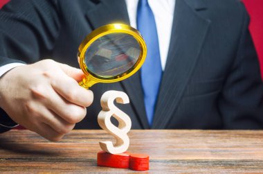 Bir adam, büyük Paragraf heykelciğinin baskısı altında olan bir adamı inceliyor. Protesto ruh hallerinin bastırılması. Gücün ele geçirilmesi. Suçlulara verilen cezayı hak etti. Taciz ve baskı