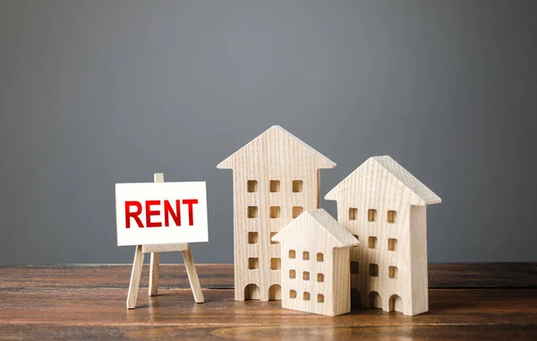 Three figures of houses and an easel with the word rent. Realtor services, search for optimal options. The concept of temporary rental housing and real estate. The choice between renting and buying. — 스톡 사진