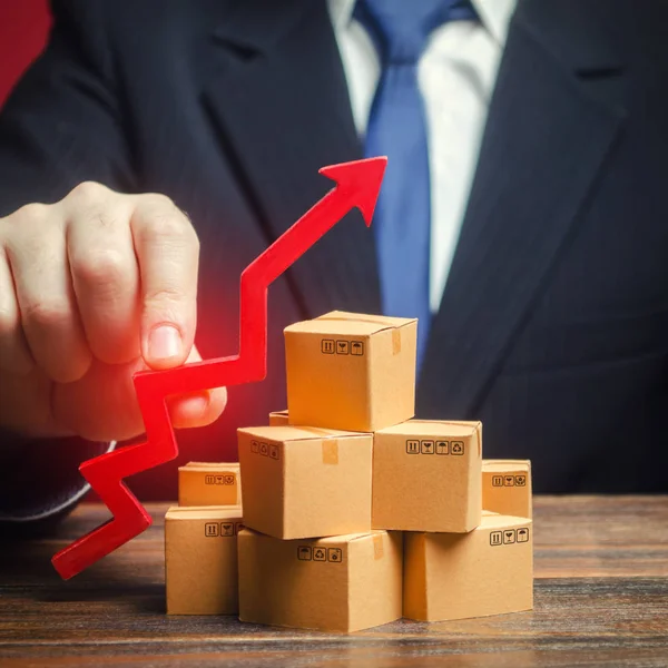 Businessman holding a red arrow up over boxes. Strategy marketing. Supply Demand. Increase sales rate, industrial goods production volumes growth , expanding export opportunities, finding new markets.