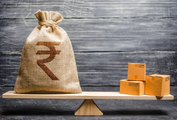 Indian rupee Inr symbol pengar väska och ett gäng lådor på skalor. Bytesbalans. Import och export, ekonomiska processer. Vinst från tillverkade varor. Tillverkning, detaljhandel — Stockfoto
