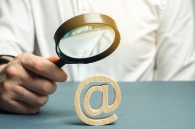 Elinde büyüteç olan bir adam bir e-posta ya da interneti inceliyor. Virüsleri kontrol et. İnternet tehditlerini değerlendir. İnternetin kamuoyu ve ekonomi üzerindeki etkisi, müdahale