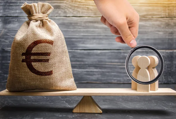 Lente d'ingrandimento è guardare un sacchetto di denaro con un segno di euro e le persone sulla bilancia. valutazione del costo del lavoro di specialisti e lavoratori. cooperazione aziendale, crowdfunding e startup . — Foto Stock