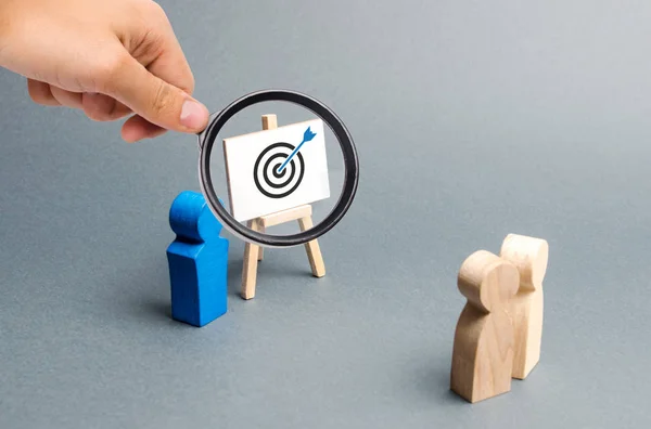 Magnifying glass is looking at leader explains employee tactics of advertising targeting. Training, briefing. Search strategies for effective advertising campaigns, customer reach. Business processes — Stock Photo, Image