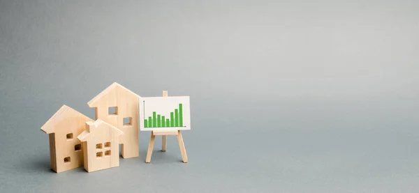 Wooden houses with a stand of graphics and information. Growing demand for housing and real estate. growth of the city and its population. Investments. banner, place for text. Selective focus