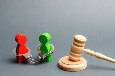 İki insan birbirine kelepçelenir ve hakimin tokmağının yanında dururlar. Mahkemede çözümü tartışın. İş anlaşmazlığı, iş ve mal paylaşımı ortaklar arasında. uzlaşma