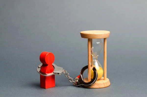 The red figure of a man is handcuffed to an hourglass. Dependence, there is little time left. Streamline business, increase efficiency and reduce downtime. Find in the shortest possible time. — 스톡 사진