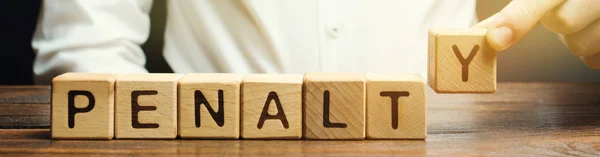 A man puts a wooden blocks with the word Penalty. Fine as a punishment for a crime and offense. Violations of traffic laws. Legalized / financial punishment. — Stock Photo, Image