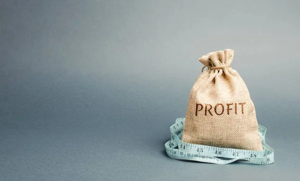 Money bag with the word Profit and tape measure. The concept of limited profit. Lack of money and poverty. Small income. Salary reduction. Unsuccessful business. Family budget. Financial crisis — 스톡 사진