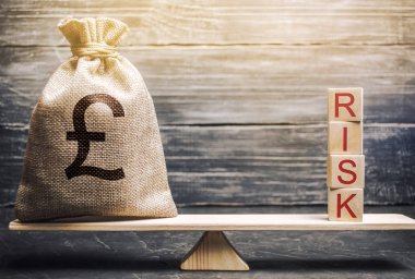 Para çantası ve ahşap bloklar. Terazide risk var. Ticari risk yönetimi ve değerlendirmesi. Stratejik, finansal ve operasyonel riskler. Sigortacılık. Ekonomi ve finans. Brexit