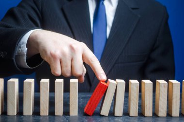 İşadamı domino taşlarını düşürme sürecini başlattı. Durduktan sonra işe başlıyorum. Çalışmaya devam etmek, engellerden kaçınmak. Korunabilirlik. Hataların ve arızaların düzeltilmesi