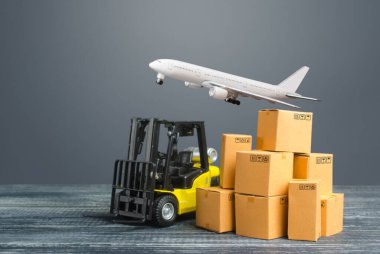 Sarı forklift, karton kutular ve nakliye uçağı. Üretim, ulaşım, kargo deposu. Nakliye gemisi. Perakende. Ulaşım lojistik altyapısı, ithalat ve ihracat malları teslimatı.