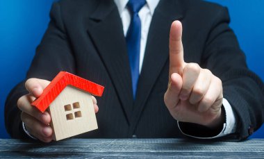 Man with a house makes a gesture of attention. Legal advice on terms a contract deal for purchase of real estate, lending and mortgage loan. Warning, indicate the nuances. Warn about risk of threat. clipart
