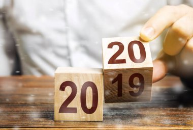 2019 ve 2020 numaralı iki tahta blok. Yeni yılın başlangıcı kavramı. Yeni hedefler. Gelecek on yıl içinde. Dünyadaki trendler. Planlar ve hedefler inşa et. Yeni fırsatlar için geleceğe taşınmak