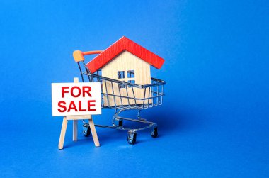 Alışveriş arabasında bir ev ve satılık bir sehpa tabelası. Gayrimenkul alıp satma, yüksek teklifler ve emlak fiyatları. Akıllı yatırımlar ve taşınma. İyi teklif.