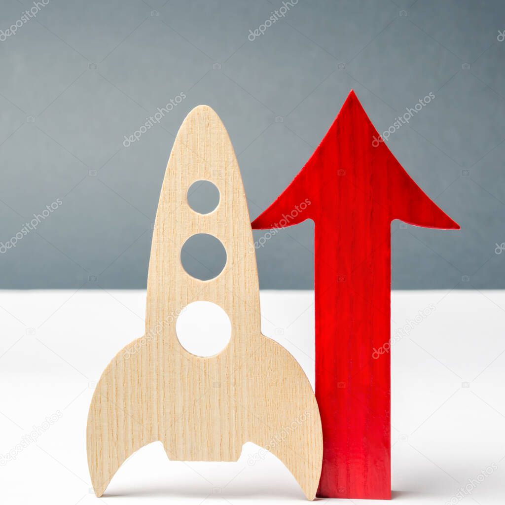 Wooden rocket and up arrow. The concept of a startup. The concept of raising fund for a startup. Charitable contributions to translate ideas or project. Investing in the future. Launch a business idea