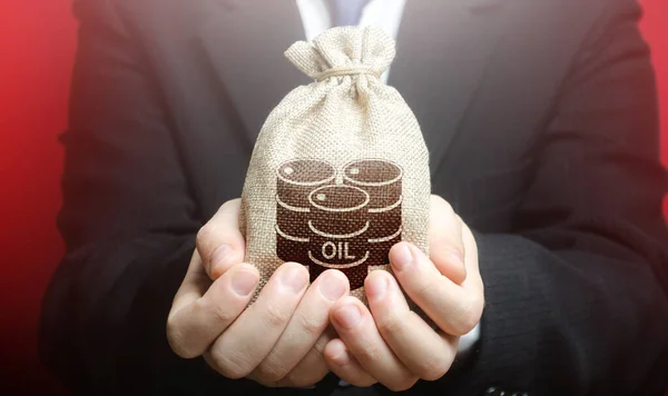 A man is holding a bag with oil barrels. Offer the purchase of oil and futures at competitive price, discounts and bonuses. Deferment of payment. Negative energy prices. Lack of storage space