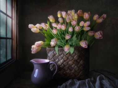 Eski tarz, beyaz sepetin içinde lüks laleler.