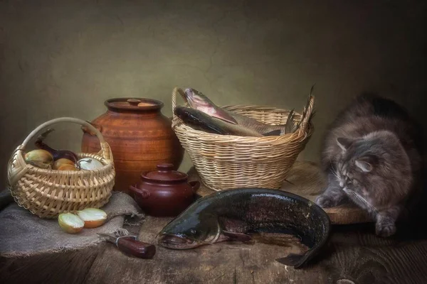 Still life with cat fish and curious kitten