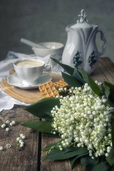 Cup of coffee and cookies with bouquet of spring flowers