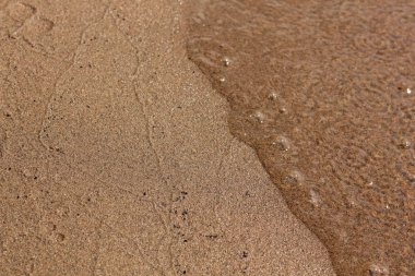 Gündüz kumlu sahilde dalgalar