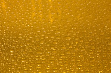 Cam, renkli arka plan üzerinde su damlaları.