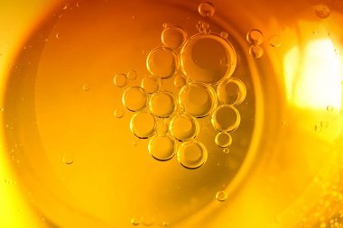 Sarı arka plan yemek, yağ kabarcıklar ve damla su.