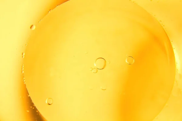 黄色の背景の料理 油の泡 水の滴 — ストック写真