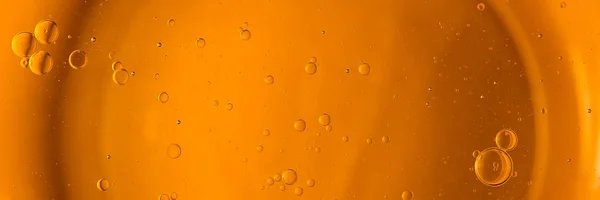 Yellow and orange bubbles, drops of oil in water, olive oil for cooking background.