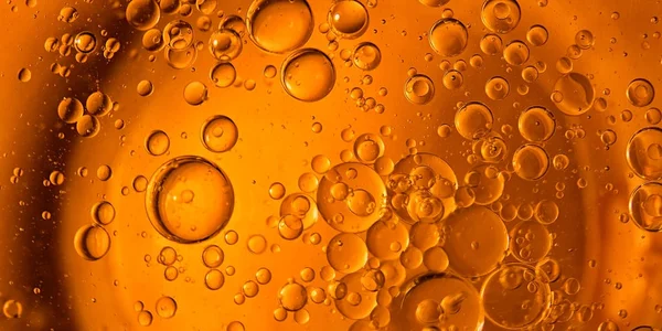 Yellow and orange bubbles, drops of oil in water, olive oil for cooking background.