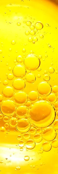 Yellow and orange bubbles, drops of oil in water, olive oil for cooking background.