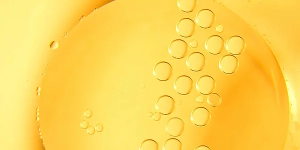 Yellow and orange bubbles, drops of oil in water, olive oil for cooking background.