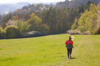 woman running  on a cloudy day with mountains