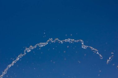 Yaz mavi gökyüzü, su damlaları içinde belgili tanımlık geçmiş karşı sıçramasına su damlaları.