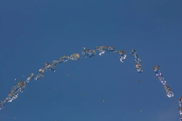 Droppar Vatten Stänk Mot Blå Sommarhimmel Vattendroppar Bakgrunden — Stockfoto