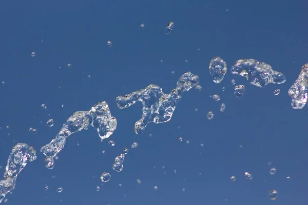 Gotas Agua Salpicando Contra Cielo Azul Verano Gotas Agua Fondo —  Fotos de Stock