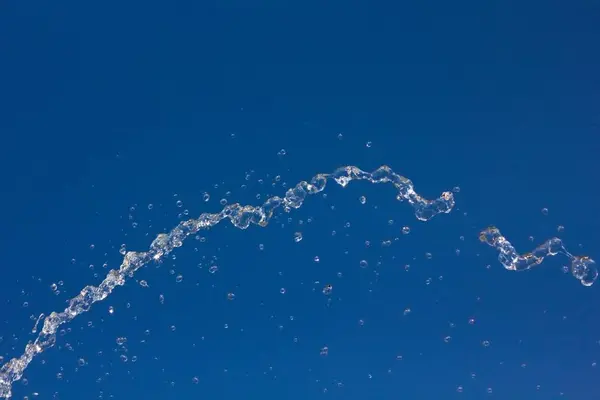 Σταγόνες Νερό Πιτσίλισμα Κατά Ένα Καλοκαιρινό Μπλε Ουρανό Σταγόνες Του — Φωτογραφία Αρχείου