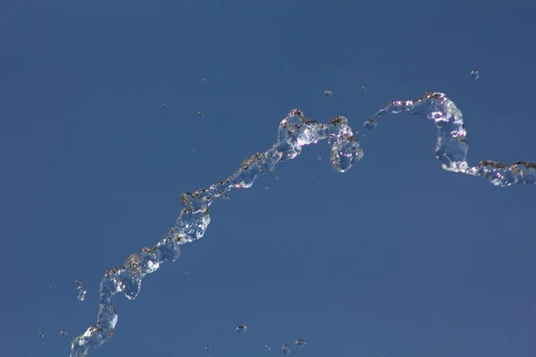 水滴在夏日蔚蓝的天空下飞溅 水滴在背景中 — 图库照片