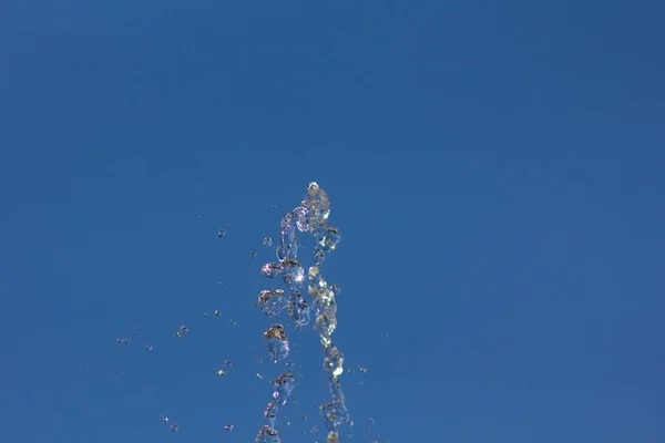 Krople Wody Rozpryskiwania Przeciwko Lato Niebieski Niebo Krople Wody Tle — Zdjęcie stockowe