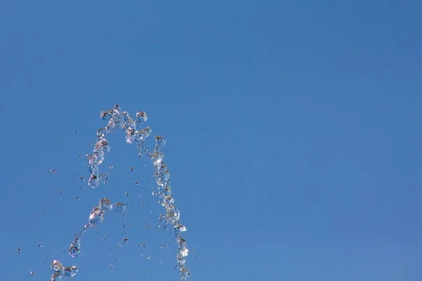 Gotas Agua Salpicando Contra Cielo Azul Verano Gotas Agua Fondo —  Fotos de Stock