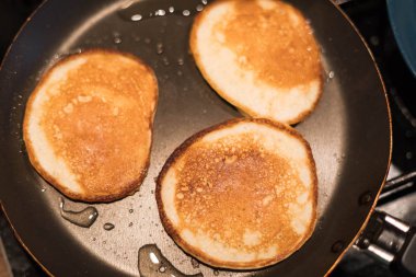 Bir tavada üç krep hazır. Hamur işleri süreci. 