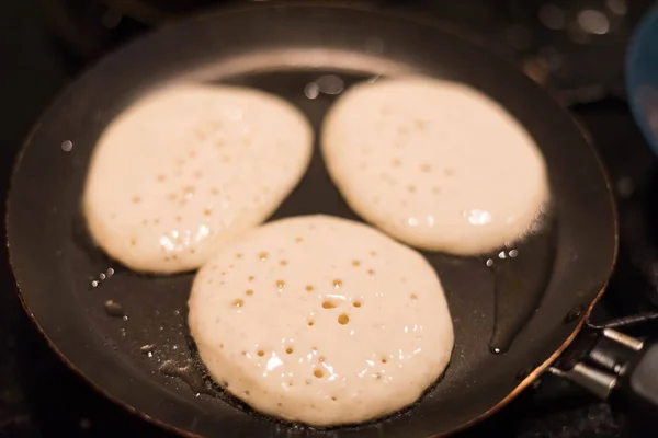 Three pancakes are prepared in a pan. Process of pastries. — Stock Photo, Image