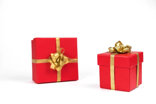 Dwa czerwone pudełka są związane złotą taśmą z prezentami na białym tle. Koncepcja wakacji i deklaracja miłości. Walentynki, ślub — Zdjęcie stockowe