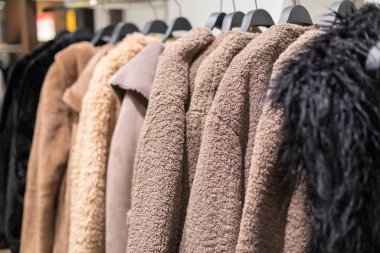 Sonbahar ve kışın giydiği askılar mağazada. kürk mantolar