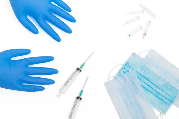 Virüs hastalıklarının yayılması için bireysel koruyucu tıbbi maskeler ve tek kullanımlık eldivenler. Coronavirus koruma eğilimi COVID-19. Tek kullanımlık steril şırıngalar ve ampullerde uyuşturucu