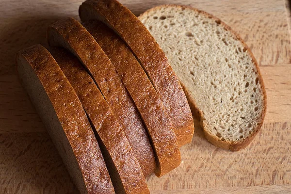 Pieces of bread on a wooden surface — Stock Photo, Image