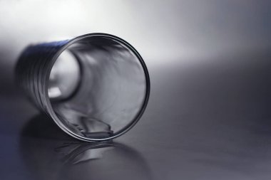 boş bir bardak bir tarafta, gri bir masanın üzerinde.