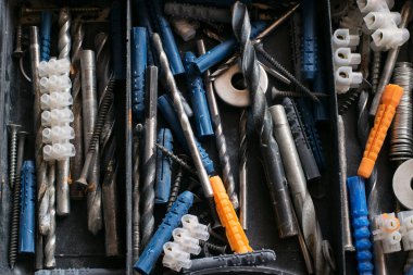 Çeşitli inşaat aksesuarları ve matkapları olan plastik kutu..