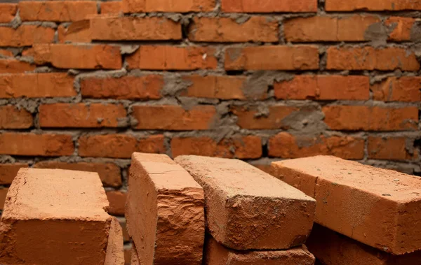 Background consisting of a brick wall and several bricks in the foreground — Stock Photo, Image