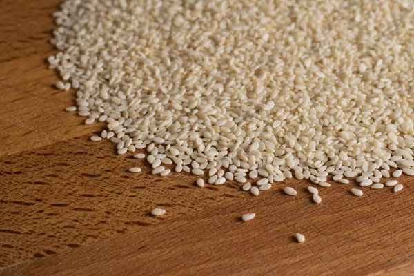Natural sesame seeds on a wooden board surface — Stock Photo, Image